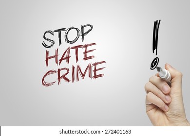 Hand writing stop hate crime on grey background