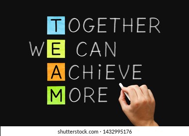 Hand Writing TEAM Together We Can Achieve More With White Chalk On Blackboard. Teamwork, Synergy Or Cooperation Business Concept.