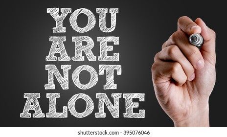 Hand writing the text: You Are Not Alone