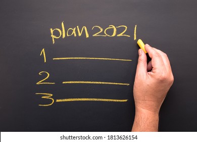 Hand writing topic of 2021 plan on chalkboard, goal setting and priority  in coming year