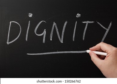 Hand writing the word Dignity on a blackboard. Being treated with dignity is important to us irrespective of age,gender or physical and mental ability - Shutterstock ID 150266762