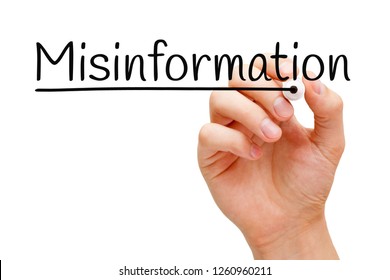 Hand writing the word Misinformation with black marker on transparent wipe board isolated on white.
