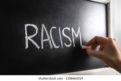 Hand Writing The Word Racism On Blackboard. Stop Hate. Against Prejudice And Violence. Lecture About Discrimination Or Stereotypes In School. 