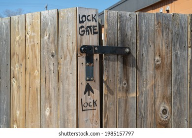 Hand Written Instructions Where To Lock A Gate On An Old Weathered Fence	
