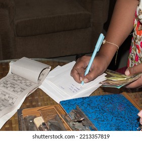 Hand Writting Tambola Prize Money With Indian Currency In Hand And  Tambola Tickets On Table. Popular Diwali And Kitty Party Game.