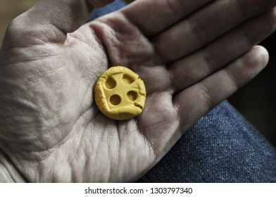 
hand with yellow button