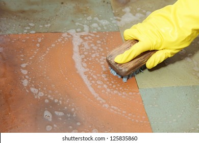 Hand In Yellow Glove Cleaning Dirty Filthy Floor With Brush Indoors