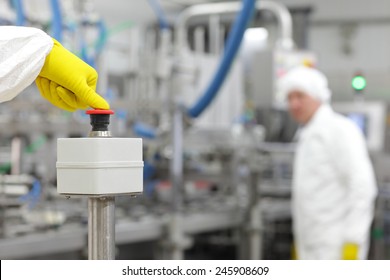 Hand in yellow  glove pressing button by thumb - starting industrial process