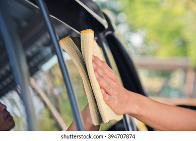 Hand With Yellow Microfiber Cloth, Cleaning Glass Car.
