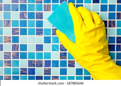 Hand In Yellow Protective Glove Cleaning Mosaic Wall With Sponge