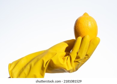 Hand In Yellow Rubber Glove For Cleaning Hold  A Lemon On A White Background, Natural Cleaning Products For Home And Kitchen, Professional Cleaning