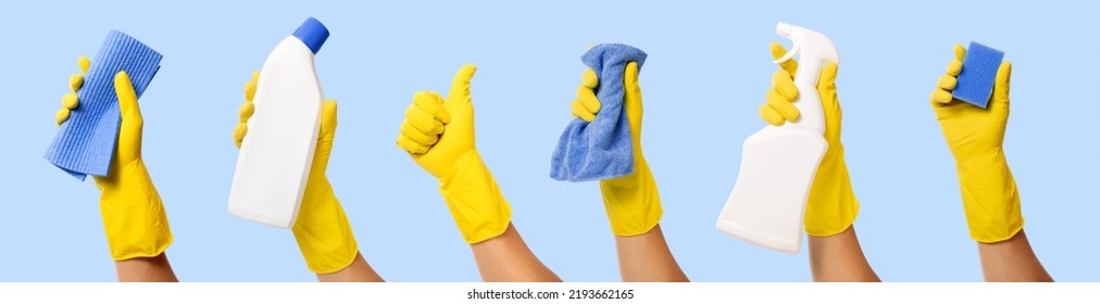 hand with yellow rubber glove holding cleaning supplies isolated on blue background. banner - Shutterstock ID 2193662165