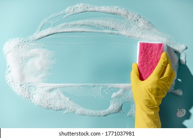 Hand in a yellow rubber glove holds a cleaning sponge and wipes a soapy foam on a blue background. Cleaning concept, cleaning service. Banner. Flat lay, top view - Shutterstock ID 1771037981