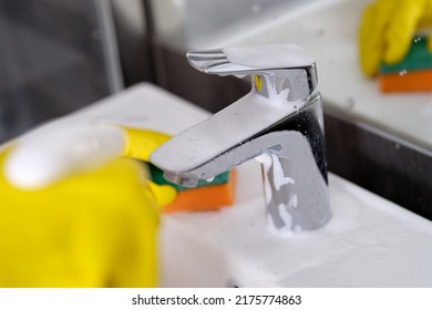 Hand In Yellow Rubber Gloves Holding Sponge For Washing Dirty Faucet With Limescale