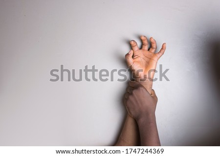 Hand of a young African girl being paped and the hand of the rapist. 