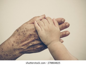 Hand Of A Young Baby Touching Old Hand Of The Elderly