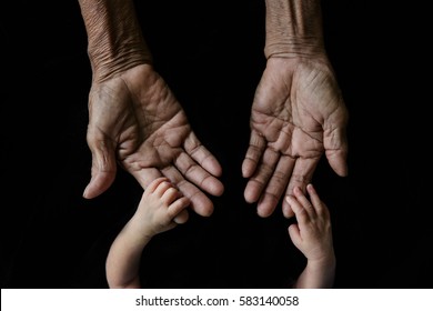 Hand Of A Young Baby Touching Old Hand Of The Elderly