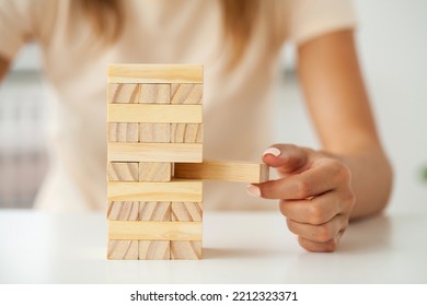 Hand of a young business woman to play wood block game with strategy and business systematic project management - Shutterstock ID 2212323371