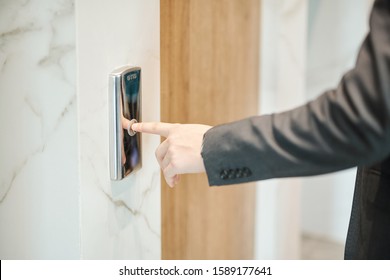 Hand Of Young Businessman Pushing Button Of Elevator While Standing By Its Door Inside Hotel Or Office Center