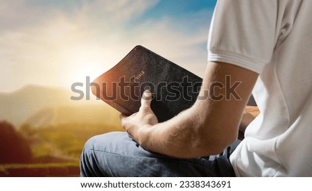 hand of young male prayer reading bible