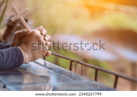 The hand of a young man praying to God for the power of God to fulfill the request of the Christian faith. The young man prayed to God for blessings based on his faith and power of faith in Him.