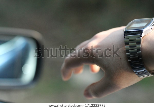 Hand of young man traveling\
by car