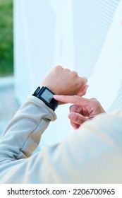 Hand Of Young Modern Sportswoman Pointing At Small Square Screen Of Smartwatch On Her Wrist While Noting Time Before Training