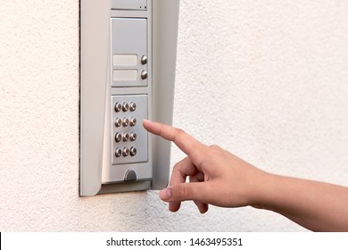 The Hand Of A Young Woman Enters A Numeric Code On The Keypad Of An Electronic Lock Or Doorbell.