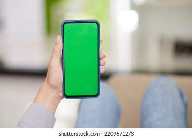 Hand Of Young Woman Holding Smartphone With Black Green Screen