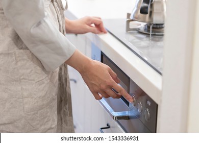 Hand of young woman pushing gas stove button in kitchen - Shutterstock ID 1543336931
