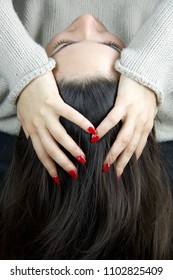 hand of  young woman with red nail polish resting on the head