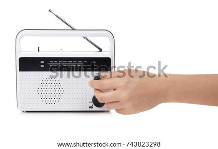 Hand of young woman with retro radio receiver on white background