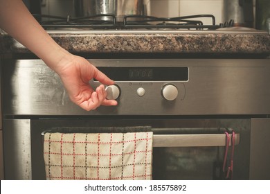 The Hand Of A Young Woman Is Turning The Knob On A Stove