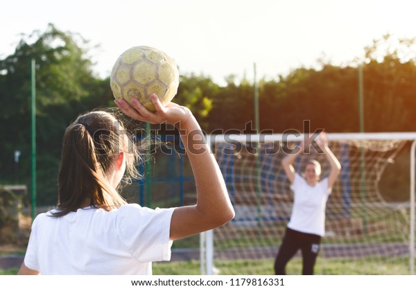 Handball players are\
playing game outside.