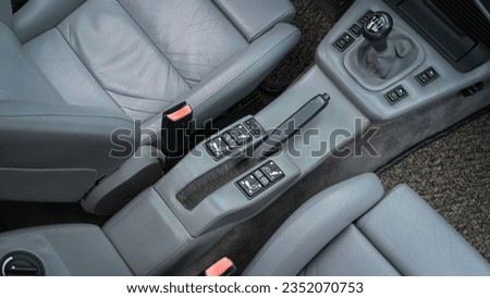 Handbrake inside of a car with grey leather