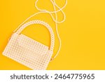 Handcraft bag made from shiny pearl imitation beads on a yellow background. Accessory with cute design.