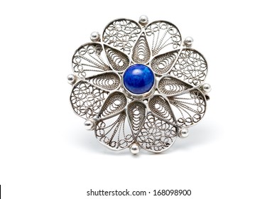 Handcrafted antique brooch in the shape of a flower with a blue stone (lapis lazuli) in the middle
