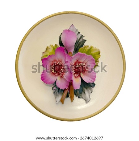 A handcrafted ceramic wall plate featuring vibrant pink flowers and green leaves in relief, set against a cream background with a golden rim. The floral motif highlights traditional craftsmanship.