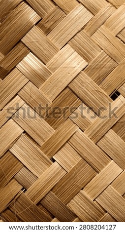 Handcrafted diagonal basketry weave pattern background. Close-up of intricately interwoven natural dried bamboo splits, showcasing organic golden-brown textures, fibrous details, and traditional Asian craftsmanship