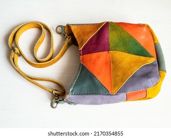 handcrafted patchwork cross body bag hand sewn from suede and leather on white background