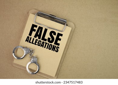 handcuffs and a blackboard with the words false allegations. the concept of false allegations. concept of justice