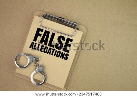 handcuffs and a blackboard with the words false allegations. the concept of false allegations. concept of justice
