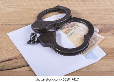 Handcuffs and euro bills