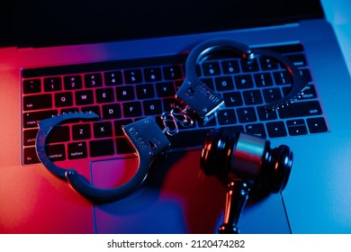 Handcuffs and gavel on a laptop. Cyber crime, online piracy and internet web hacking concept