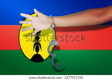 handcuffs with hand on New Caledonia flag