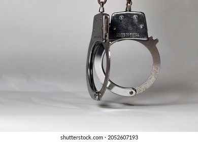 
Handcuffs Hanging On Gray Background 