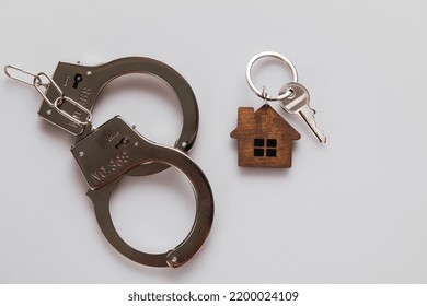 Handcuffs And House Keys. Real Estate And Fraud Concept.