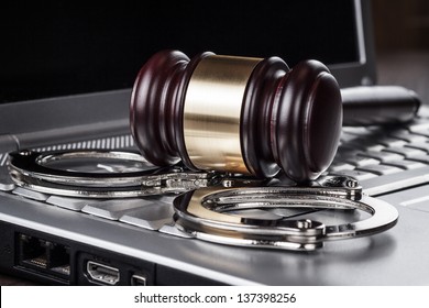 Handcuffs And Judge Gavel On Computer Cyber Crime Concept