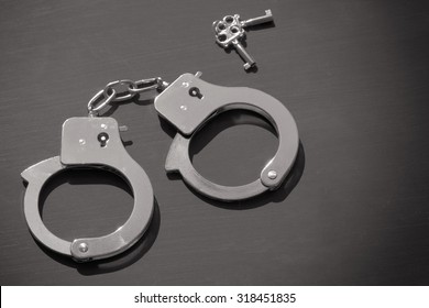 Handcuffs and keys on dark background