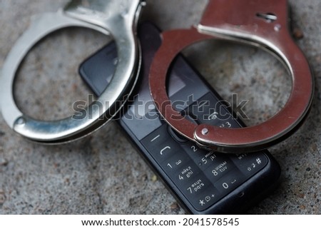 handcuffs lie on a cell push-button telephone. phone fraud concept. High quality photo